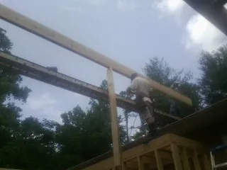 Carpenter setting a ridge beam over a new addition frame — Ice Dam Removal by Roofing Brothers in Newtown Square