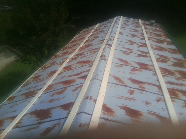 Rusted metal roof panels with new wood purlins before replacement — Storm Damage Roof Repair in Newtown Square by Roofing Brothers