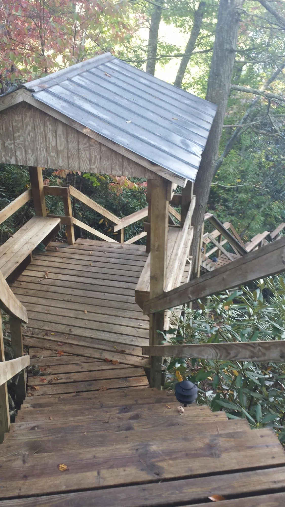 Metal roofed shelter over wooden steps on a wooded walkway — Skylight Repair & Installation work by our crew in Newtown Square
